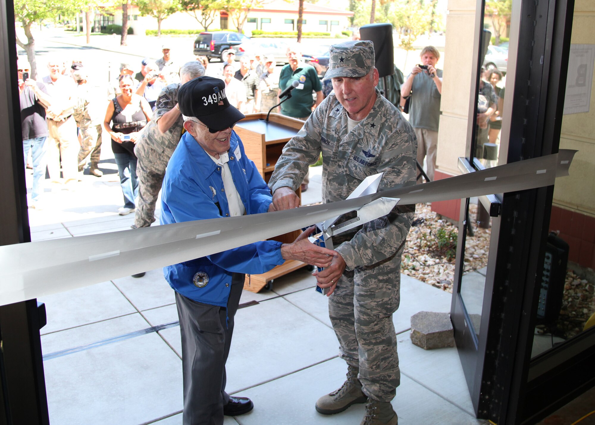 TRAVIS AIR FORCE BASE, Calif. --Mr. Joe Rowan, representing 349th alumni, and Brig. Gen. John C. Flournoy, Jr., 349th Air Mobility Wing commander, cut the ceremonial ribbon opening the Heritage Hall in the Wing Headquarters during Alumni Day, June 2, 2012 at Travis Air Force Base, Calif.  The day's events also included the ribbon cutting ceremony for the; a BBQ lunch sponsored by the 349th Chiefs Group, the 349th Officer's Spouses Club and Mr. Stanley Davis; and a static display tour of a C-17 Globemaster III.  The day's festivities cumulated with a banquet featuring remarks by Brig. Gen. Dale R. Baumler, former 349 AMW and 14th Air Force commander; and by General Flournoy; and music by the Band of the Golden West. (U.S. Air Force photo / Lt. Col. Robert Couse-Baker)
