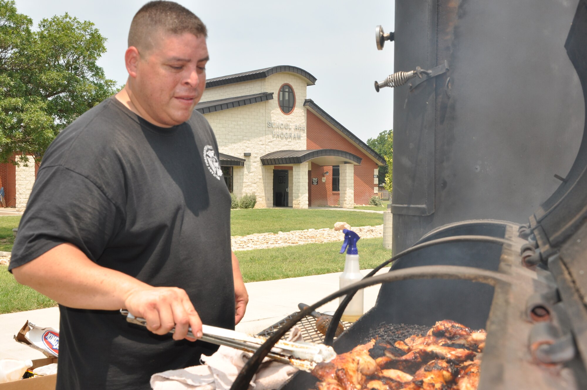 GOODFELLOW AIR FORCE BASE, Texas -- Staff Sgt. Ricardo Campos, 312th Training Squadron, cooks up chicken, sausage, and beans for the staff of the Child Development Center, School Age Program, and Youth Center. Campos and his boys are very appreciative of all the help they have received from the child care staff. (U.S. Air Force photo/ Staff Sgt. Tong Duong)
