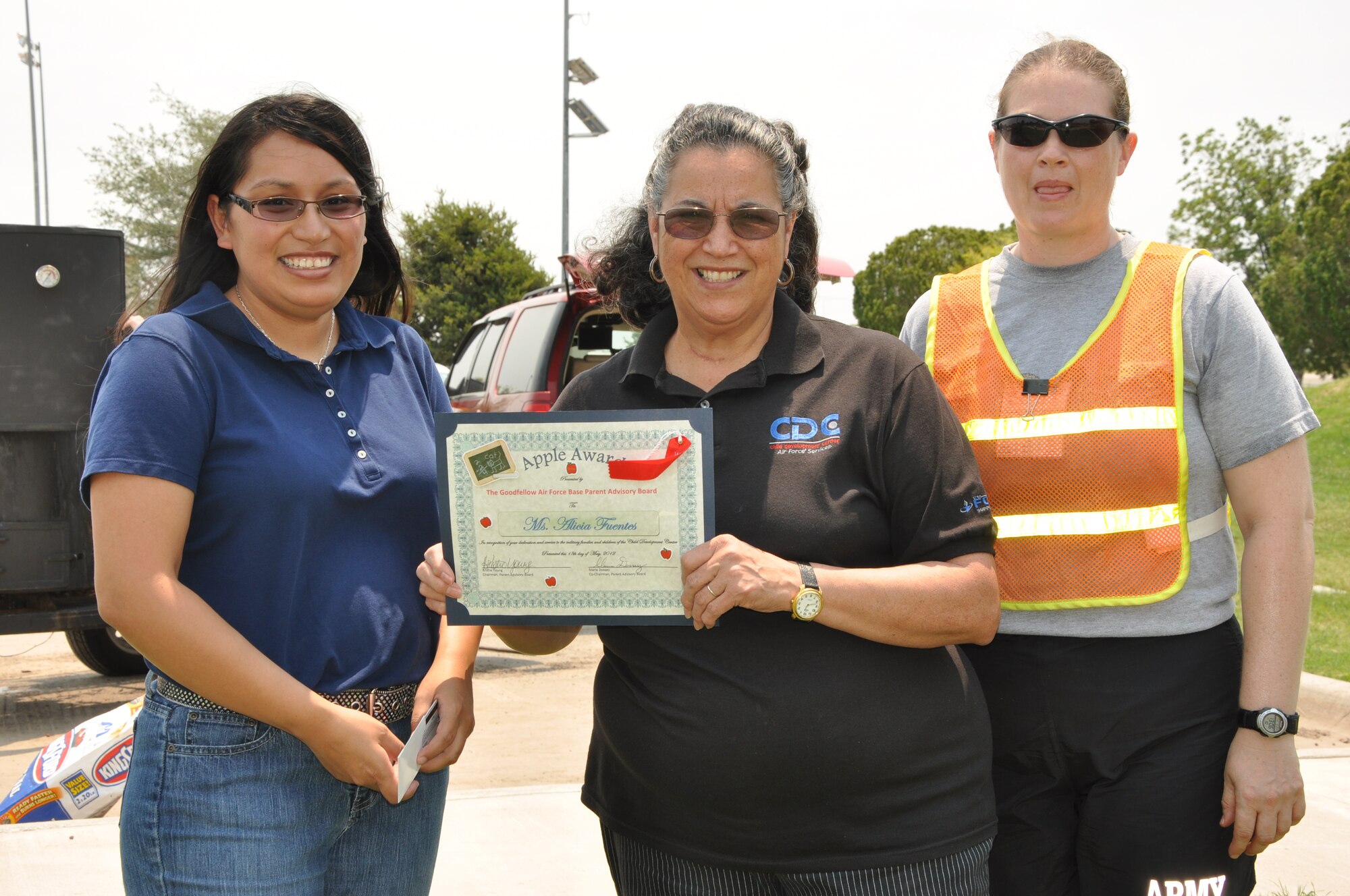 GOODFELLOW AIR FORCE BASE, Texas -- Parent’s Advisory Board members Maria Dossey, 316th Training Squadron (left), and Sgt. 1st Class Kristie Young, 344th Military Intelligence Battalion (right), present Ms. Alicia Fuentes the “Apple Award” for going above and beyond in caring for the children at the Child Development Center. Each month, parents of the Child Development Center nominate and vote on a caregiver to receive a $25 gift card, certificate and VIP parking spot. (U.S. Air Force photo/ Staff Sgt. Tong Duong)