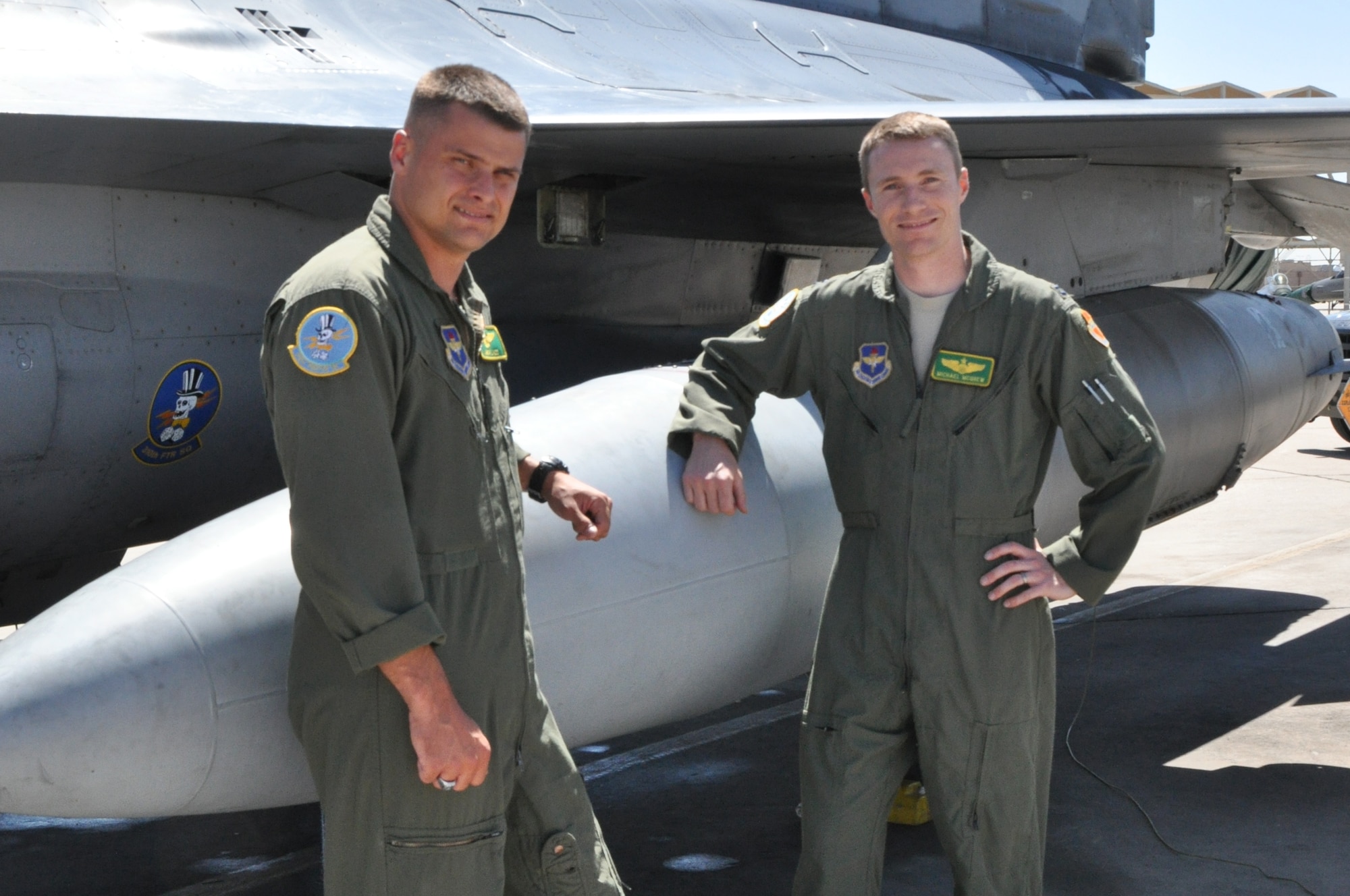 Marine Corps Maj. Jason Ladd and Air Force Capt. Michael McGrew, 310th
Fighter Squadron instructor pilots, pose for a photo next to an F-16
Wednesday at Luke Air Force Base. Ladd is currently particpating in the
Joint Service Pilot Exchange Program at Luke and McGrew is on his way to
Marine Corps Air Station Miramar, Cali., to start. (U.S. Air Force photo by Senior Airman Melanie Holochwost)
