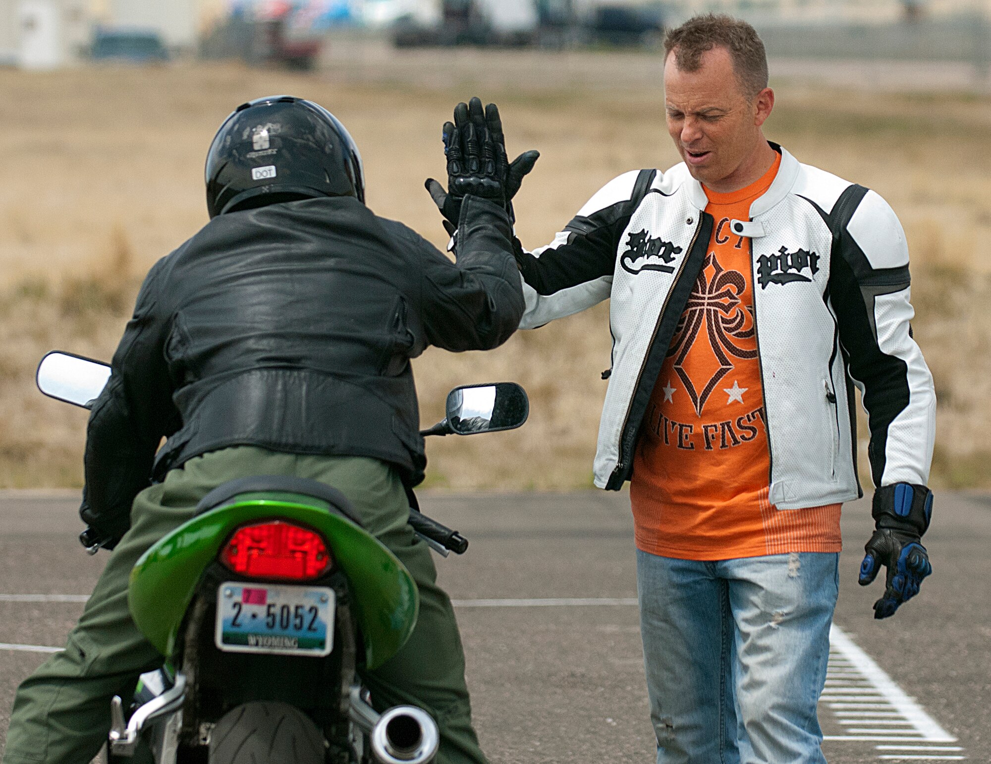 Tech. Sgt. Christopher Laubin, 90th Operations Group, high-fives 1st Lt. Philip Duddles, 90th OG, after Duddles successfully completes an exercise during the first Military Sportbike Rider Course offered by the 90th Missile Wing traffic safety office May 30, at F. E. Warren Air Force Base, Wyo. Laubin was the course instructor. (U.S. Air Force photo by R.J. Oriez)