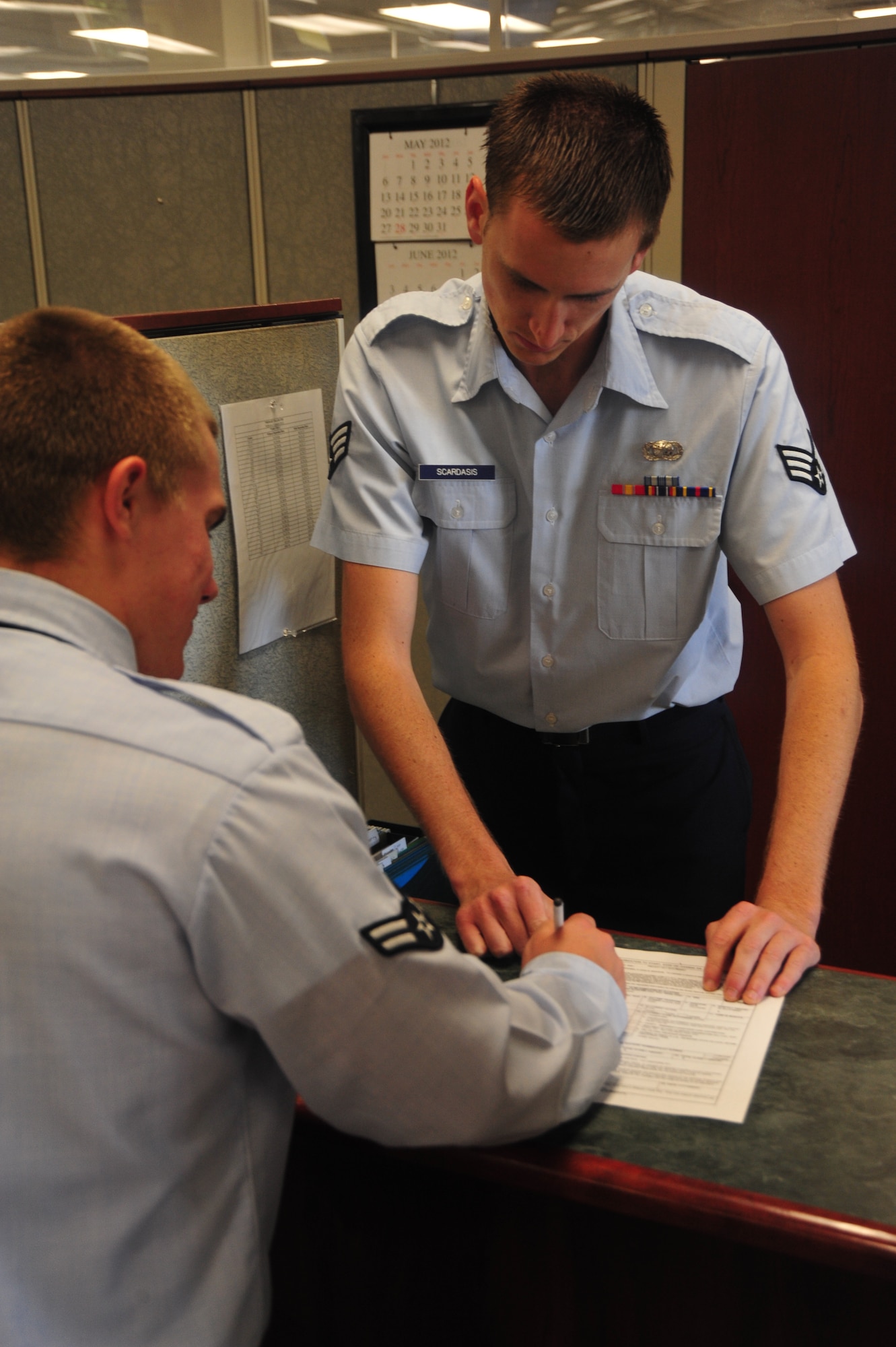 Senior Airman Christopher Scardasis, finance technician, Headquarters Air University Financial Management Flight, assists a customer at the finance office customer service desk May 21. Maxwell’s finance office helps an average of 600 customers monthly. (Air Force photo by Airman 1st Class William Blankenship)
