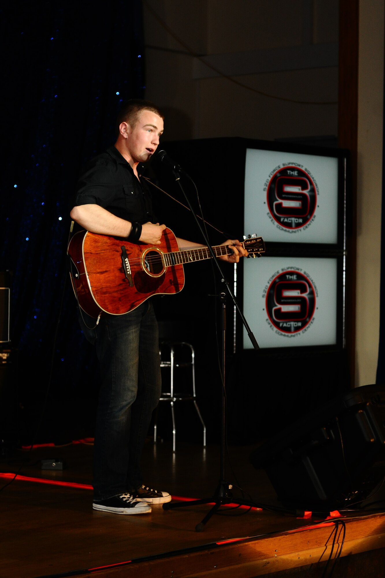 SPANGDAHLEM AIR BASE, Germany -- Ty Prager, 52nd Equipment Maintenance Squadron, performs "Small Town" by John Mellencamp during the first Spangdahlem Factor Talent Show at the Brick House here June 6. The 52nd Force Support Squadron-sponsored talent show showcased four local vocalists and three local bands competing in their respective categories for prize money. (U.S. Air Force photo by Airman 1st Class Dillon Davis/Released)