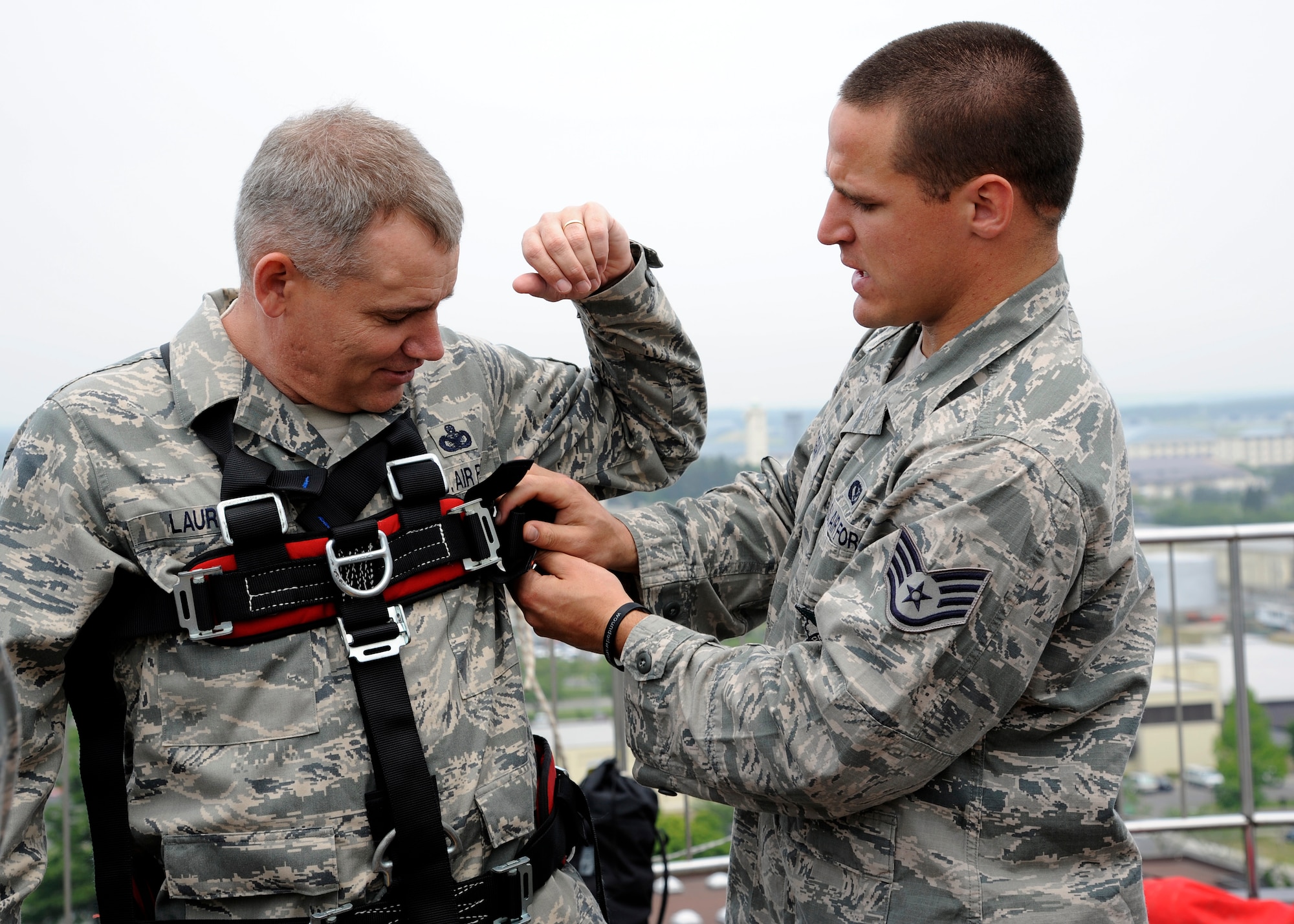 U.S. Air Force Staff Sgt. Matthew Duggan, right, 35th Civil Engineer Squadron 
crew chief, secures a harness for Chief Master Sgt. James Laurent, 35th Fighter Wing command chief, during warrior day rappel training at Misawa Air Base, Japan, June 8, 2012. Airmen with the 35 CES fire department taught rappel training as part of their monthly warrior day training. (U.S. Air Force photo by Tech. Sgt. Marie Brown)

