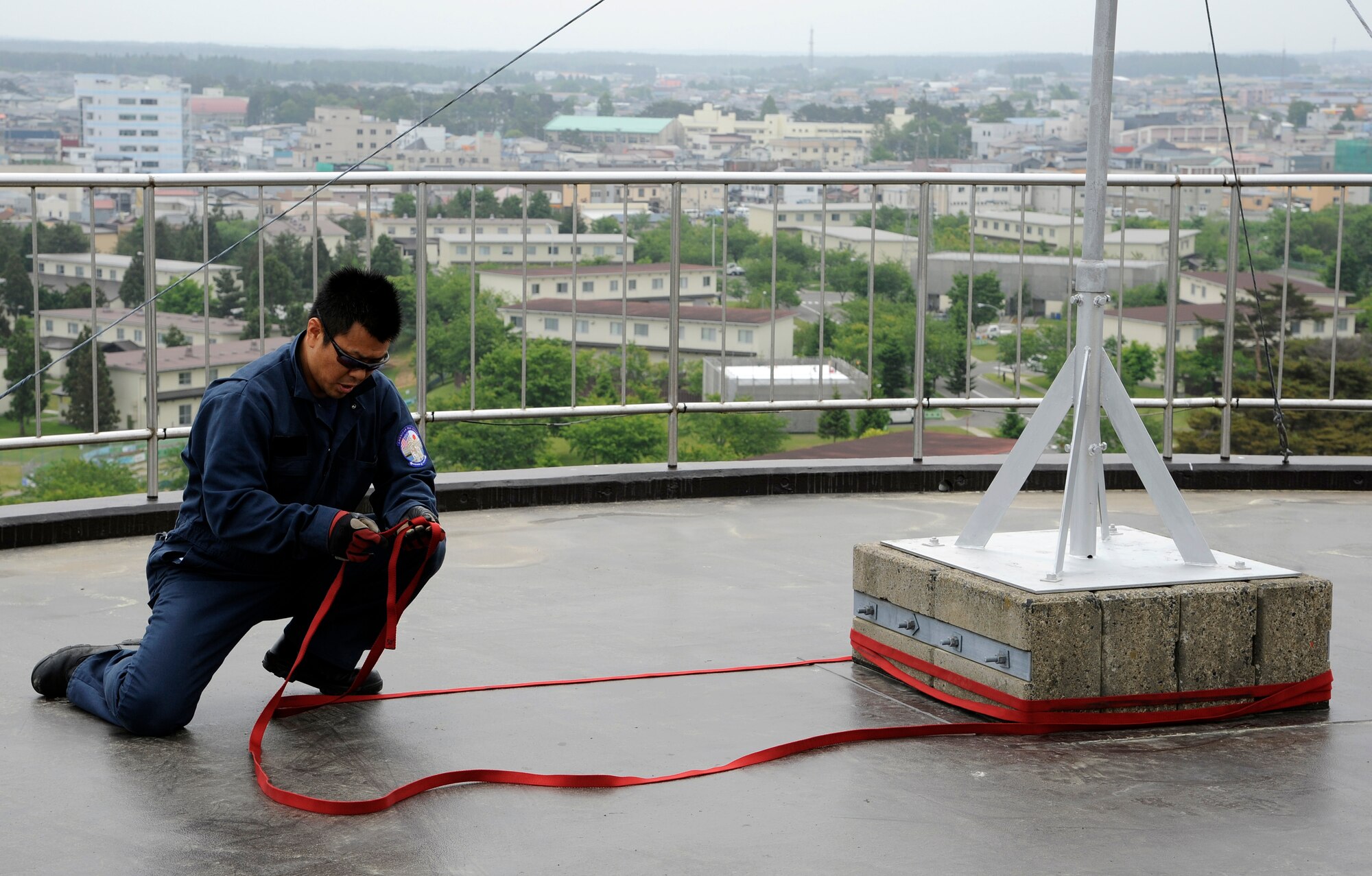 Takuya Kanto, 35th Civil Engineer Squadron driver operator, secures an anchor point on top of the Misawa water tower for rappel training at Misawa Air Base, Japan, June 8, 2012. The 35 CES conducted rappel training as part of warrior day, a monthly event focused on honing readiness skills. (U.S. Air Force photo by Tech. Sgt. Marie Brown)