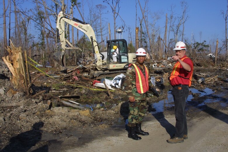 A U.S. Army Corps of Engineers Vicksburg District deployee and Mississippi National Guardsman discuss debris removal.