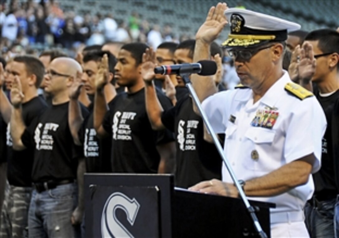 Navy Rear Adm. David F. Steindl gives the oath of enlistment to 86 men from the Chicago-area, Indiana, and Wisconsin at the 27th annual Chicago White Sox Navy Night in Chicago, June 5, 2012. Steindl, commander of Naval Service Training Command, was the event's guest of honor and threw out the first pitch after enlisting the new recruits.