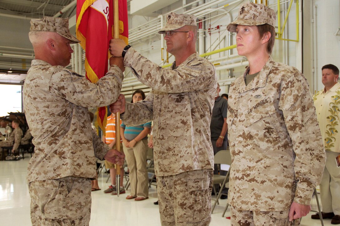 Marine Wing Support Squadron 471 Headquarters Detachment Sgt. Maj. Duane G. Hauer presents the Marine Corps flag to Lt. Col. Christopher J. Busch during a change of command ceremony at the St. Paul Air National Guard Base June 9. Busch relinquished command to Lt. Col. Priscilla P. Failmezger.