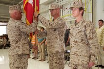 Marine Wing Support Squadron 471 Headquarters Detachment Sgt. Maj. Duane G. Hauer presents the Marine Corps flag to Lt. Col. Christopher J. Busch during a change of command ceremony at the St. Paul Air National Guard Base June 9. Busch relinquished command to Lt. Col. Priscilla P. Failmezger.