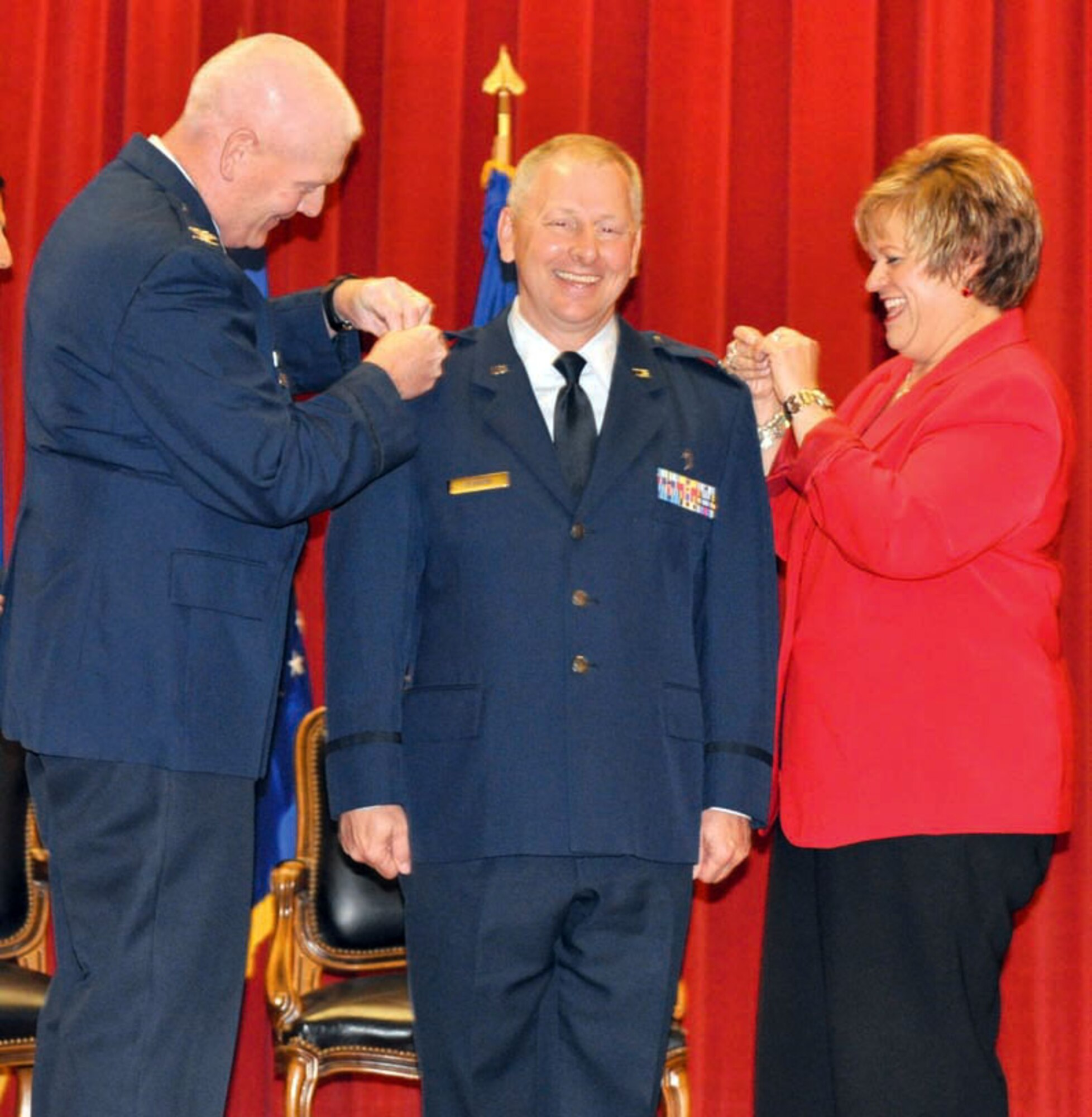 Colonel Steve O’Brien (center), 4th Air Force chaplain, smiles as Col. John
Morris, 4th Air Force A6 director, and his wife, Laurie O’Brien, pin on the rank
of colonel on the epaulets of his service jacket during a promotion ceremony at
the Cultural Resource Center, March Air Reserve Base, Calif., held June 1. (U.S. Air Force photo by Maj. Andra Higgs)