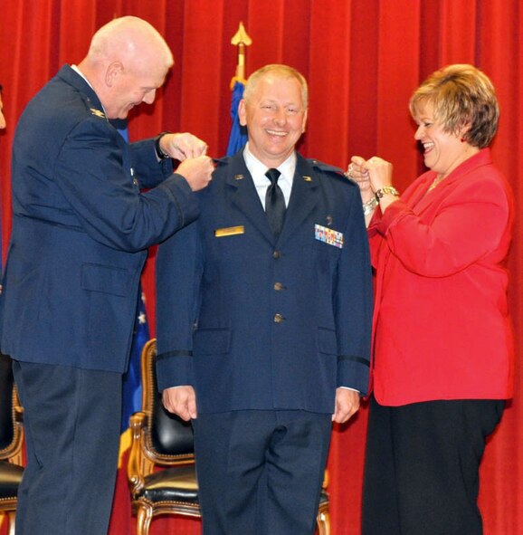 Colonel Steve O’Brien (center), 4th Air Force chaplain, smiles as Col. John
Morris, 4th Air Force A6 director, and his wife, Laurie O’Brien, pin on the rank
of colonel on the epaulets of his service jacket during a promotion ceremony at
the Cultural Resource Center, March Air Reserve Base, Calif., held June 1. (U.S. Air Force photo by Maj. Andra Higgs)