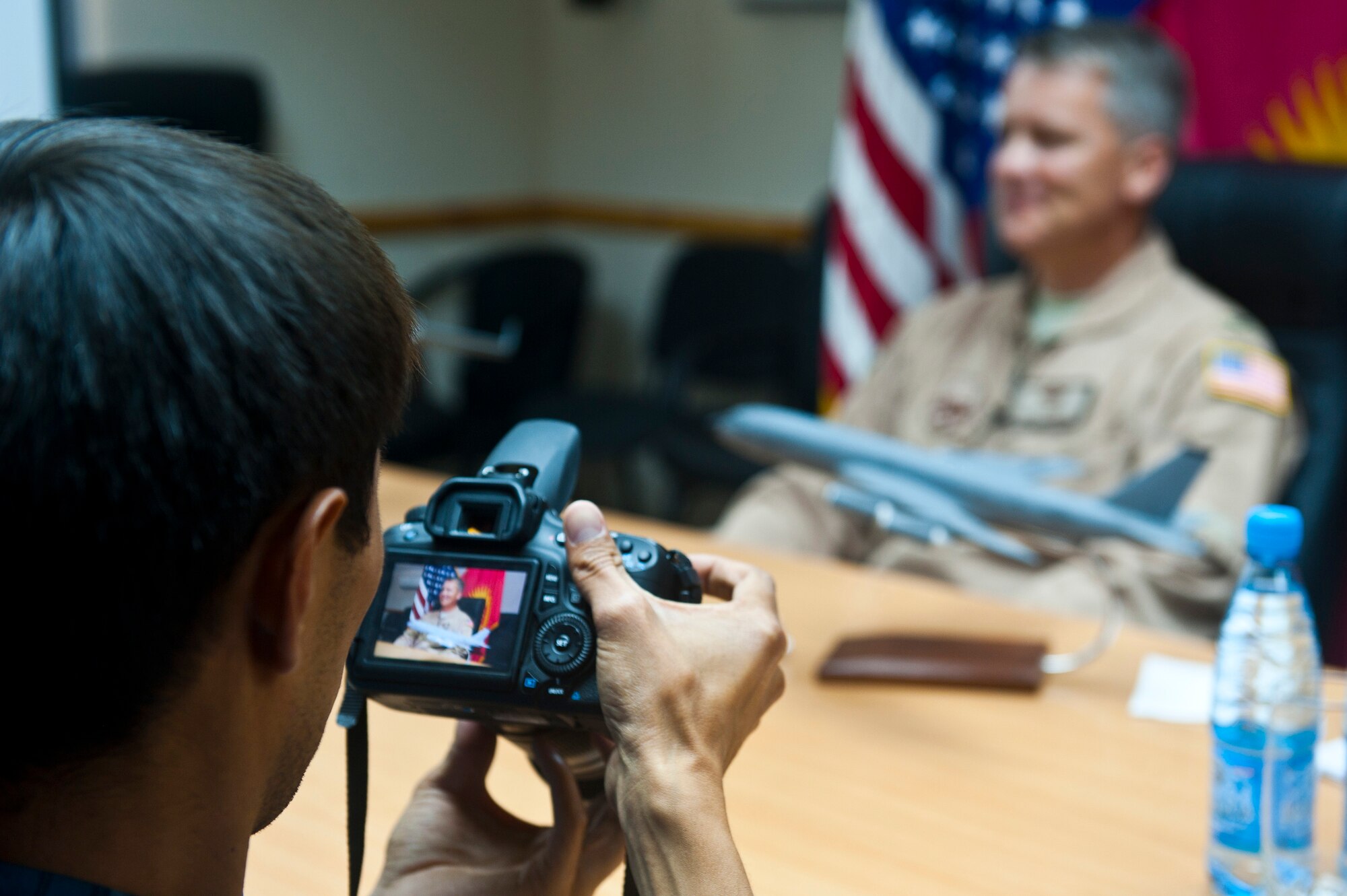 Janarbek Djoldoshbaev previews a photo on his camera during an interview with Col. James Jacobson at the Transit Center at Manas, Kyrgyzstan, June 8, 2012. Jacobson said that it was an amazing experience being able to work with our Kyrgyz Republic partners throughout his tenure here. Jacobson is the 376th Air Expeditionary Wing commander and Djoldoshbaev is a cameraman with the Azattyk Broadcasting Company. (U.S. Air Force photo/Senior Airman Brett Clashman)