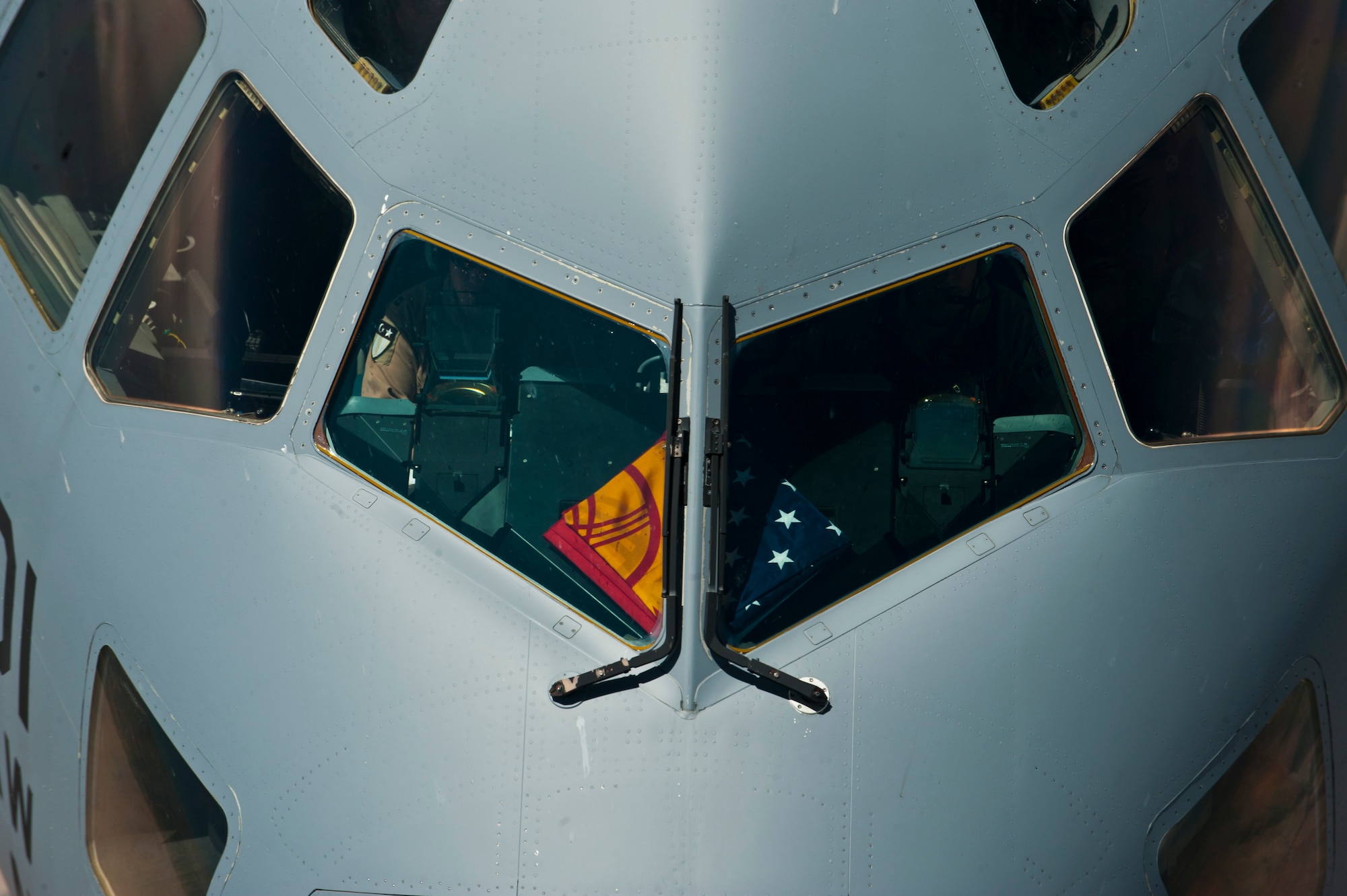 A C-17 Globemaster III flies over Kyrgyzstan with the Kyrgyz Republic and American flags displayed in their windshield, June 8, 2012. The flags represent the ongoing partnership between the Kyrgyz Republic and the United States. (U.S. Air Force photo/Senior Airman Brett Clashman)