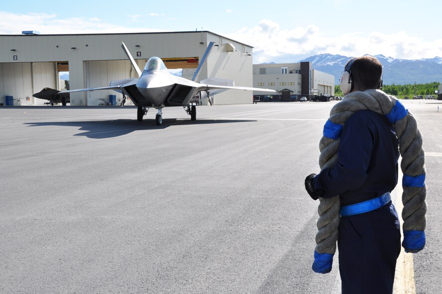 Tech. Sgt. Bobby Breher, 477th AMXS, waits to chock an F-22 before conducting an end of runway inspection during the 477th Fighter Group Unit Training Assembly weekend here June 9.  During an end of runway inspection the maintainers inspect the landing gear, hydraulic systems, weapons systems and all exterior panels and doors for leaks, loose or missing hardware or other damage that would be unsafe for flight. The UTAs are an opportunity for the pilots in the 302nd Fighter Squadron to conduct Reserve flying operations.  During the week the Reserve pilots and maintainers integrate with their active duty counterparts in the 525th and 90th Fighter Squadrons. (U.S. Air Force photo/Capt. Ashley Conner) 