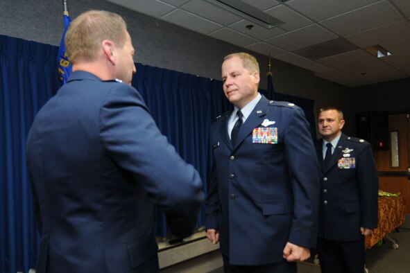 JOINT BASE ELMENDORF-RICHARDSON, Alaska - Lt. Col. Scott Coniglio accepts command of the 176 Maintenance Squadron from Col. Mark Hedlund, 176 Maintenance Group commander after Col. Michael Griesbaum relinquished command of the squadron June 6, 2012. Coniglio will be in charge of more than 200 Airmen responsible for the maintenance of the fixed-wing aircraft and helicopters. National Guard Photo by Tech. Sgt. Jennifer Theulen.
