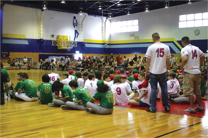 All the Marine Corps Air Station Iwakuni youth baseball teams and their coaches sit patiently awaiting the start of the ceremony representing the end of the youth baseball season here June 9, 2012, at the IronWorks Gym sports courts. Teams lined up to receive their certificates for all their hard work and dedication to their teams and the league throughout this baseball season.