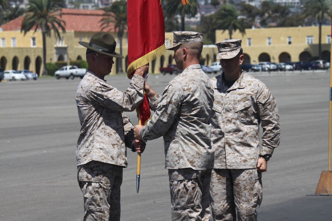 Lt. Col. Michael R. Hodson, oncoming Support Battalion commanding officer, Recruit Training Regiment,center, passes the organizational colors to 1st Sgt. Terry E. Harrelson, Support Bn. sergeant major, RTR, left, on the Shepherd Field Parade Deck aboard Marine Corps Recruit Depot San Diego June 8.  Lt. Col. William A. Gallardo, outgoing Support Bn. commanding officer, right, relinquished command to Hodson by presenting him with the colors, symbolizing the transfer of responsibility.