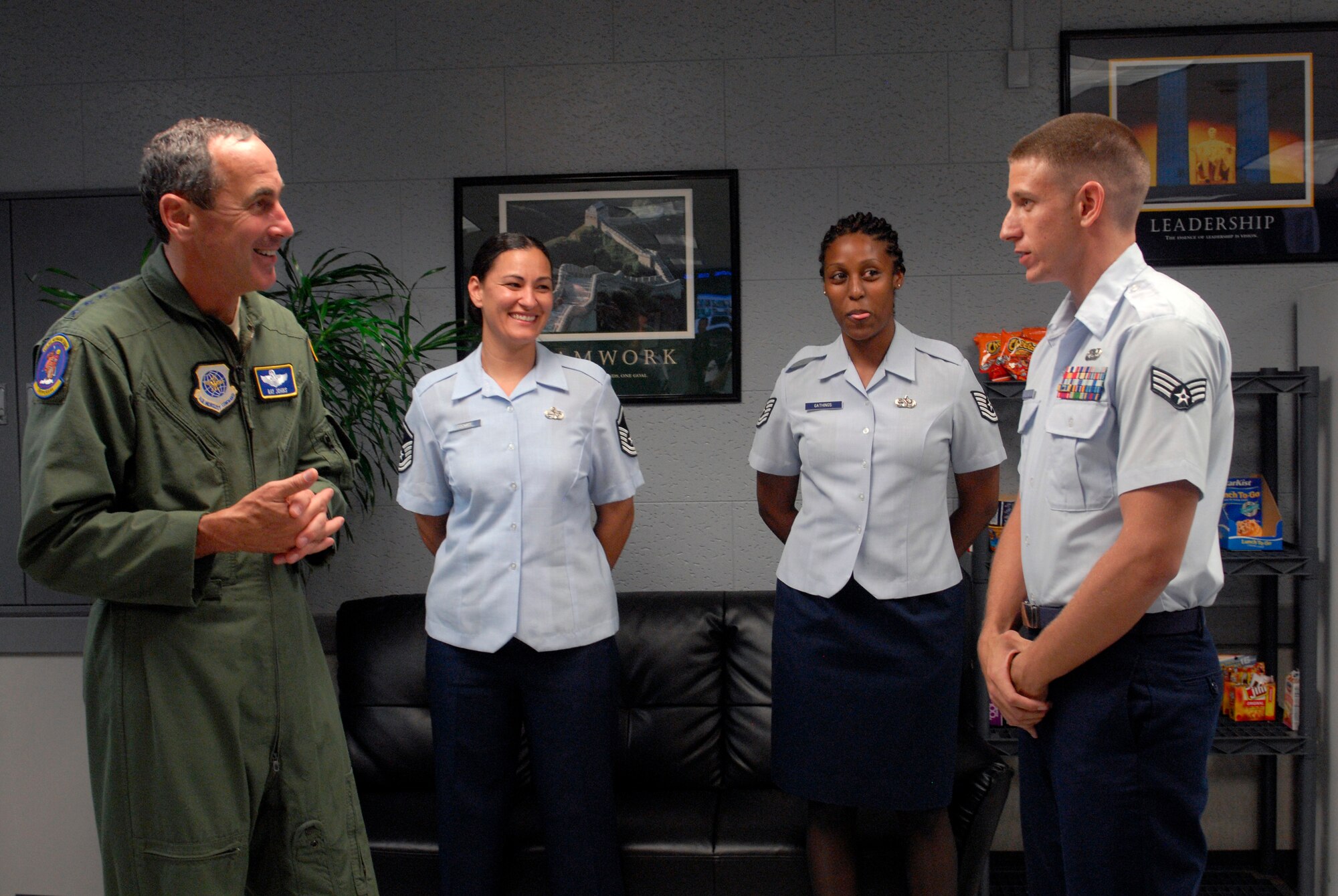 Senior Airman Ryan Rae, an air tactical operations center controller, explains to General Raymond Johns, Air Mobility Command commander at Scott Air Force Base, III., accomplishments of the Airmen working at the 733rd Air Mobility Squadron command center on Kadena Air Base, Japan, June 11, 2012. General Johns visited Team Kadena's associate unit to show his appreciation for Airmen's execution and acceleration of global air mobility operations. (U.S Air Force photo/Airman 1st Class Malia Jenkins)