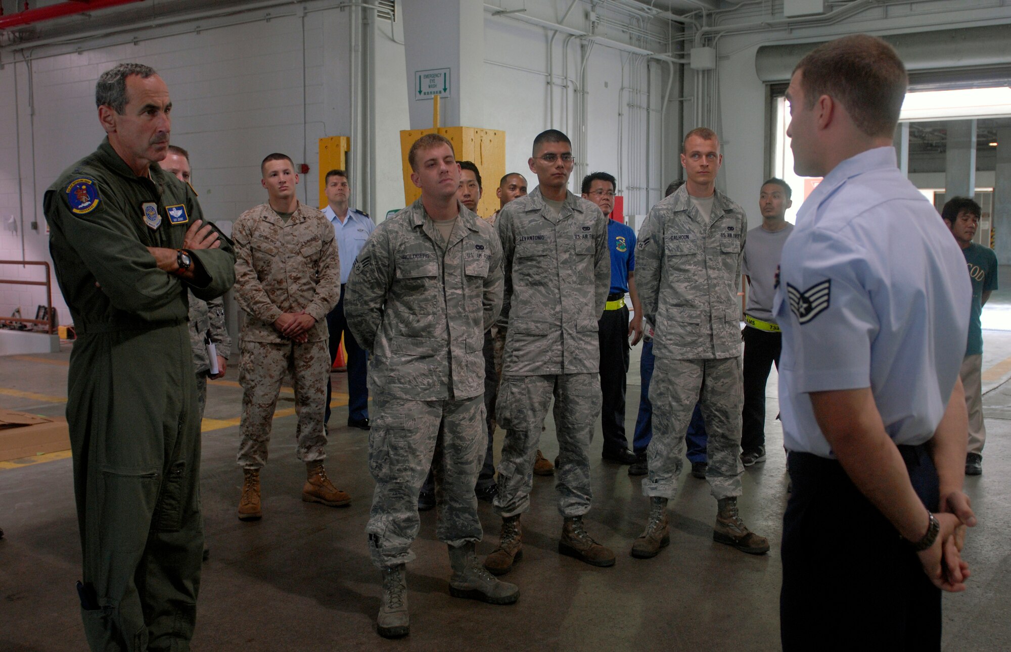 Staff Sgt. Victor Lanni, an air freight supervisor, briefs General Raymond Johns, Air Mobility Command commander, Scott Air Force Base, III., and fellow service members about the accomplishments of the 733rd Air Mobility Squadron's freight services unit during the general's visit to Kadena Air Base, Japan, June 11, 2012. Lanni also talked about the implementation of the theater consolidation shipping point. The 733rd AMS mission is to execute and accelerate global air mobility operations. (U.S Air Force photo/Airman 1st Class Malia Jenkins) 
