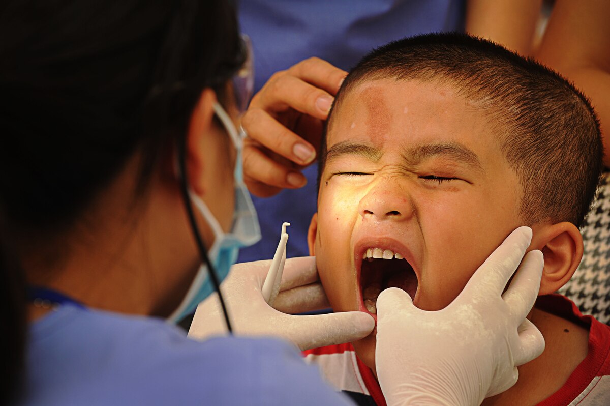 A young Vietnamese boy opens his mouth for a dental assistant to examine during Pacific Angel-Vietnam in Nghe An Province, Vietnam, June 11. The dental clinic, a class room at the Xuan Lam Primary School, was filled with children getting their first dental cleanings. The children were sent home with tooth brushes, tooth paste and fresh teeth. Operation Pacific Angel gives the U.S. an opportunity to support the efforts of the other governments in the Pacific  region by providing medical, dental, optometry and engineering assistance to the host nation citizens.(U.S. Air Force photo/Senior Airman Lauren Main)