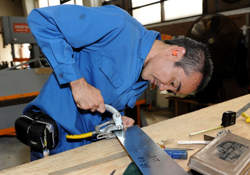 Munenori Yamakawa, 18th Civil Engineer Squadron, working on a switch cover panel at the metal fabrication shop on Kadena Air Base, Japan, June 11, 2012. There are 10 military and 20 local national workers at the shop. The metal fabrication shop does many things, such as welding, sheet metal duct work and oxyacetylene cutting in support of 18th CES mission. (U.S. Air Force photo/Junko Kinjo)