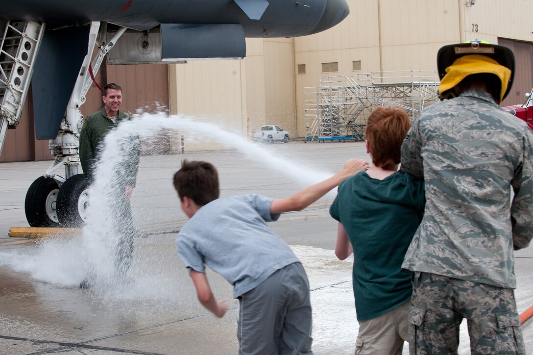 Family and friends of Col. Steven Hiss, 28th Bomb Wing vice commander, spray him with a water hose and champagne after his final B-1 flight at Ellsworth Air Force Base, S.D., June 7,2012. After 26 years of flying airplanes, the moment was bittersweet as Hiss was congratulated and thanked by family and friends after stepping down from a B-1 for the last time. (U.S. Air Force photo by Airman 1st Class Kate Thornton/Released)