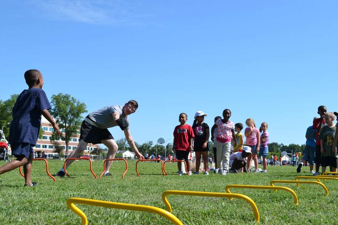 U.S. Army Spc. Nick Fackler from the 155th Inland Cargo Transfer Company, 10th Transportation Battalion, 7th Sustainment Brigade here, fixes a hurdle that was knocked over during General Stanford Elementary School's field day at Ft. Eustis, Va., June 7, 2012. The school requested 15 Soldiers per day for the two-day event. (U.S. Army photo by Spc. Ondirae H. Abdullah-Robinson/Released)