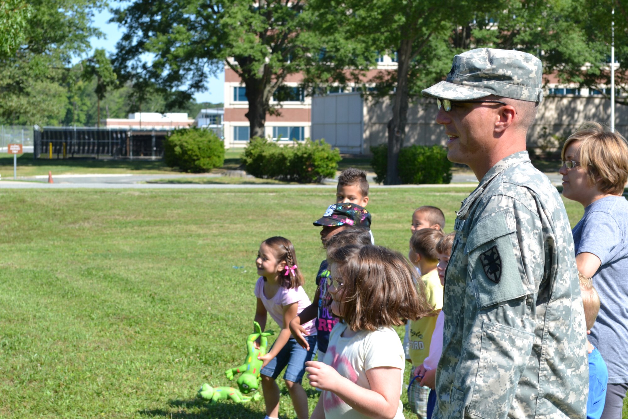 U.S. Army Sgt. Lawton Davis, assigned 359th Inland Cargo Transfer Company, 10th Transportation Battalion, 7th Sustainment Brigade, watches a group of students carry rubber frogs between their legs during General Stanford Elementary School's field day at Ft. Eustis, Va., June 7, 2012. There were numerous tasks and more than 20 different activities for the Soldiers to help the students with, including potato sack races, kick-bowling, relay races and popcorn, a game involving a parachute and hats. (U.S. Army photo by Spc. Ondirae H. Abdullah-Robinson/Released)