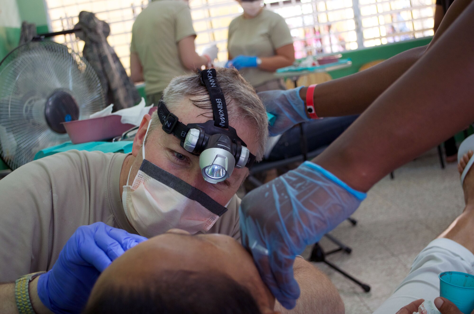 Lt. Col. William Dunlap, 944th Medical Squadron dentist, conducts a tooth extraction at a temporary clinic set up at a school in Puerto Plata, Dominican Republic. 944th medical Squadron members partnered with Reserve and Guard members from nine different units last month on a Medical Humanitarian mission to the Dominican Republic.  The 47 person U.S. team, made up of medical, dental, optometry and pharmacy personnel, provided care to more than 10,000 patients during their 15 day visit. (U.S. Air Force Photo by Maj. Alan Mirly) 