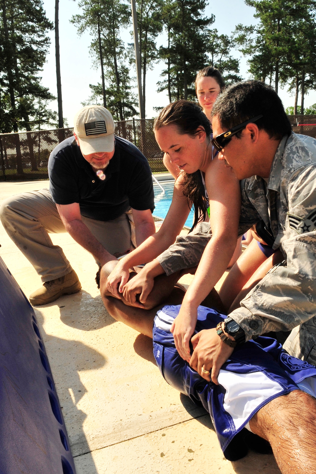 Lifeguards learn what to do in case of a spinal injury at an in-service emergency training class at the Woodland Pool, Shaw Air Force Base, S.C., May 31, 2012. The 20th Medical Operations Squadron instructed this exercise.(U.S. Air Force photo by Airman Nicole Sikorski/Released)