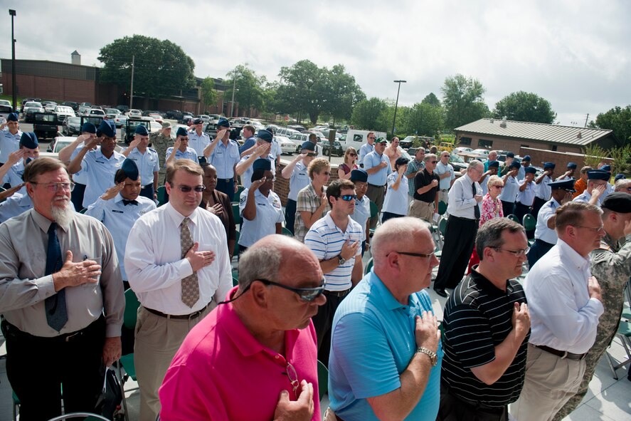 Airmen and Valdosta community members pay respects during the playing of the national anthem during a ribbon-cutting ceremony for the new 93d Air Ground Operations Wing and 23d Mission Support Group headquarters building June 11, 2012, at Moody Air Force Base, Ga. The ceremony featured remarks from U.S. Air Force Col. Billy Thompson, 23d Wing commander, and a tour of the facility after the ribbon was cut. (U.S. Air Force photo by Staff Sgt. Jamal D. Sutter/Released) 