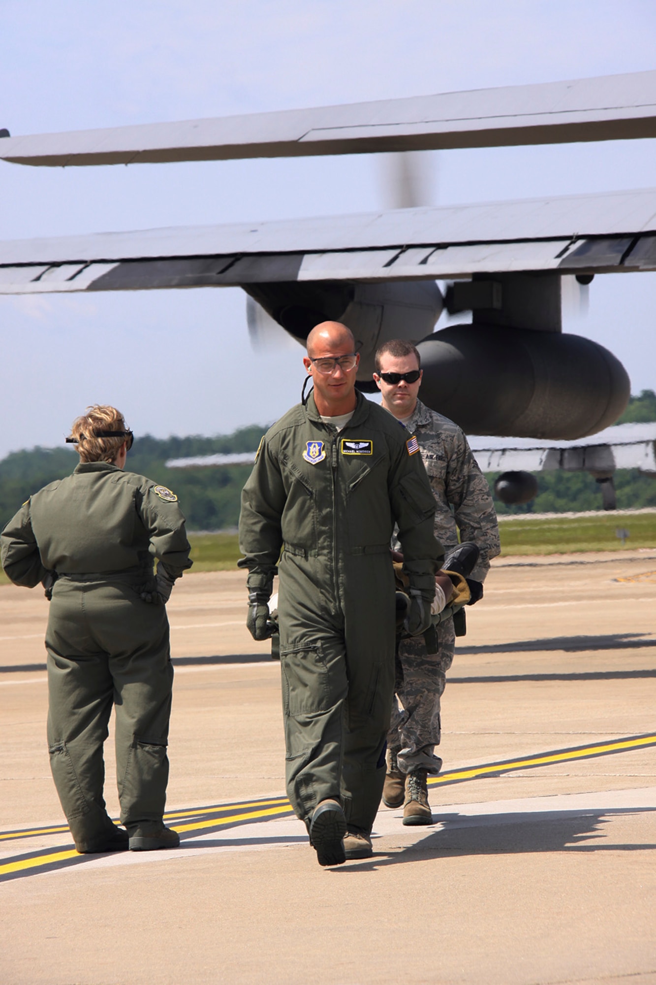 Capt. Michael Homovich and Senior AirmanTimothy McDaniel of the 911th Aeromedical Squadron, carry a patient from a C-130 Hercules to an awaiting vehicle during an engines running off-load exercise, June 3, 2012. The ERO exercise simulates landing in a hot zone where unloading patients and cargo as fast as possible is critical to the minimization of time on the ground. The procedure is practiced to maintain safe operations of the aircraft while off-loading crews, cargo, or passengers. (U.S. Air Force photo by Senior Airman Jonathan Hehnly/Released)