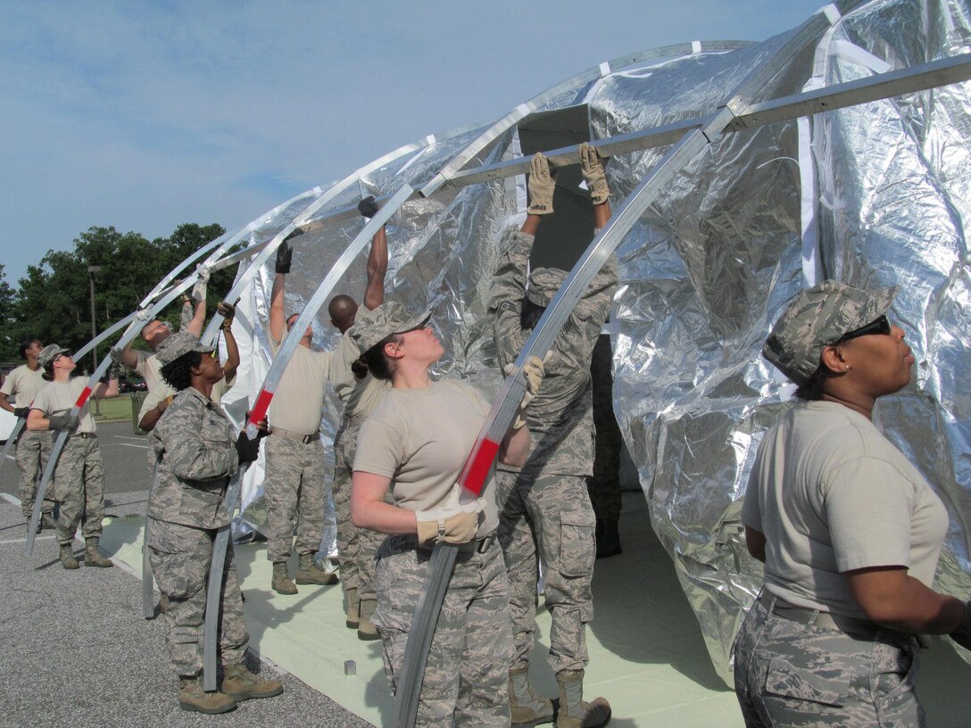 The 779th Medical Group conducted an exercise to hone their disaster-response skills June 6 near Chapel 1 on Joint Base Andrews. Two Expeditionary Medical Support Teams, made up of more than 50 members each, constructed and took down a 25-bed field hospital. Here members install the wall frame of the shelter. (AF Photo by Melanie Moore)