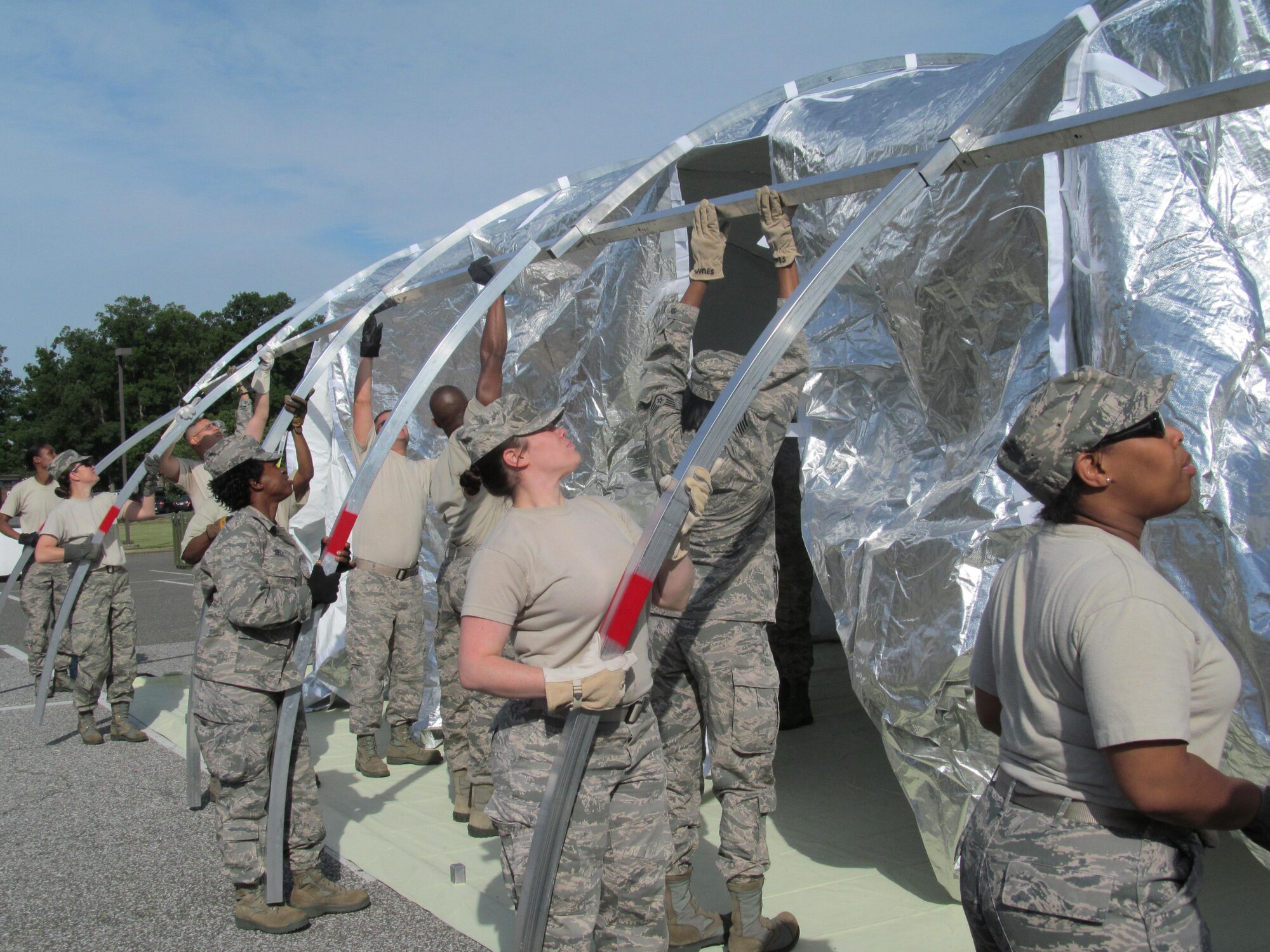 The 779th Medical Group conducted an exercise to hone their disaster-response skills June 6 near Chapel 1 on Joint Base Andrews. Two Expeditionary Medical Support Teams, made up of more than 50 members each, constructed and took down a 25-bed field hospital. Here members install the wall frame of the shelter. (AF Photo by Melanie Moore)