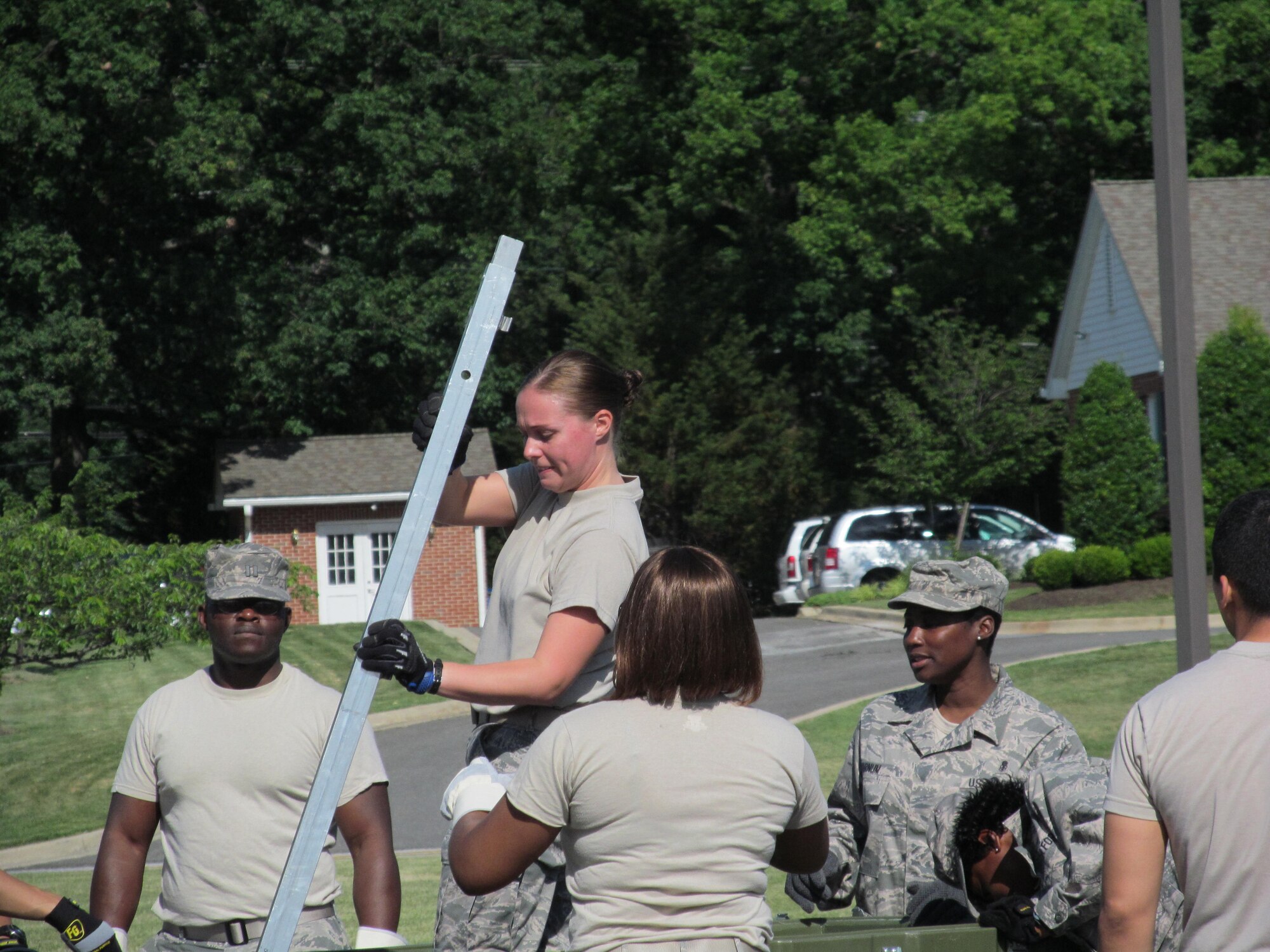 Senior Airman Aimee Lessard, 779th Medical Group medical logistics technician for contracting services hands frames to Tech Sgt. Laveena Pugh, Non-Commisioned Officer In-Charge for contracting services so they can set up the field hospital on June 6, 2012.  The 779th Medical Group conducted the exercise to hone their disaster-response skills  on Joint Base Andrews. Two Expeditionary Medical Support Teams, made up of more than 50 members each, constructed and took down a 25-bed field hospital. (AF Photo by Melanie Moore)