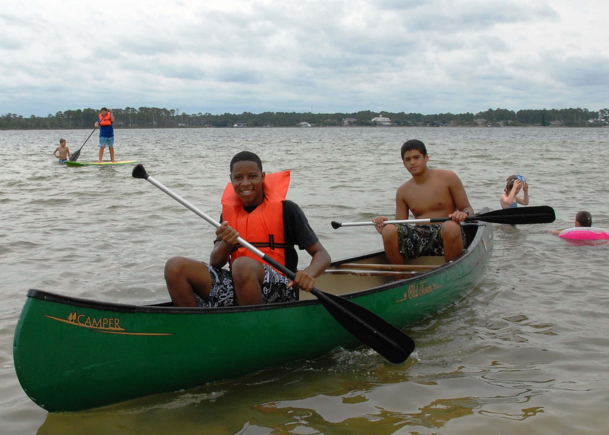 Ronnell Lyle (front) and Ivan Rojas row their canoe to shore at the Team Eglin Picnic at Post’l Point June 8.  The event featured free food and entertainment for Eglin personnel and families, including a water slide, bouncy house, climbing wall, bungee jumping and horseback riding. (U.S. Air Force photo/Kevin Gaddie)