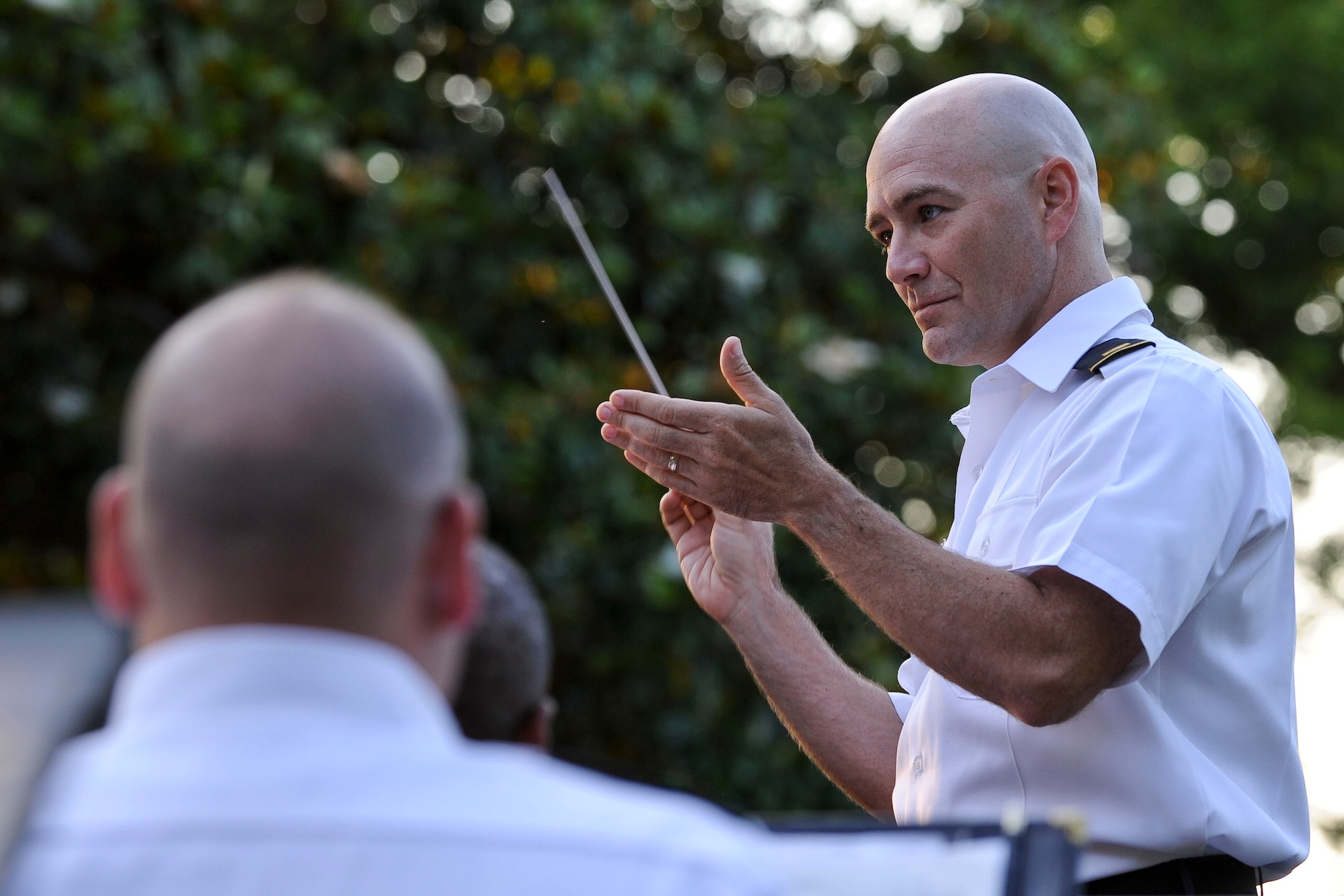 U.S. Army 2nd Lt. Silas Huff, U.S. Army Training and Doctrine Command Band executive officer, directs the band during a song during the “Music Under the Stars” concert series opener at Ft. Eustis' Magnolia Park, June 7, 2012. During the performance, the band played more than 10 songs, including “King Cotton” by J.P. Sousa and Lee Greenwood's “God Bless the U.S.A.” (U.S. Air Force photo by Senior Airman Wesley Farnsworth/Released)