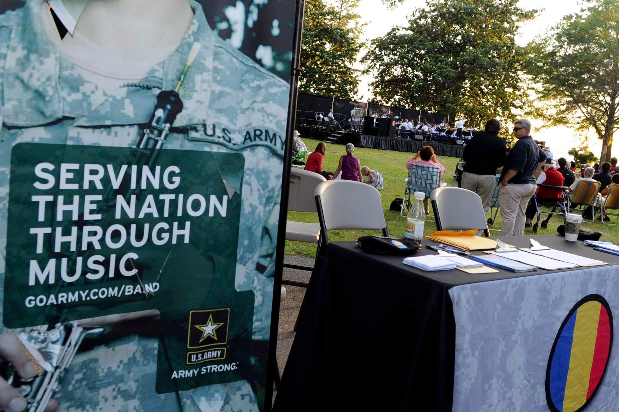 A table with programs and information about the U.S. Army Training and Doctrine Command Band welcomes fans as they enter Ft. Eustis' Magnolia Park on the opening night of the “Music Under the Stars” concert series, June 7, 2012. During the performance the band played more than 10 songs including “Rolling Thunder” by Henry Fillmore and “Fiesta” by Philip Sparke. (U.S. Air Force photo by Senior Airman Wesley Farnsworth/Released)