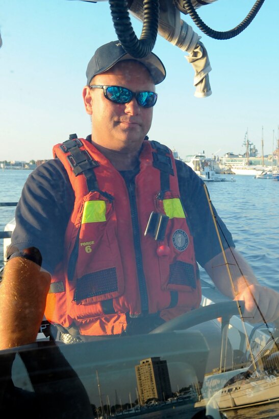 Mel Vermillion, a Ft. Eustis firefighter, navigates the waters of the Elizabeth River at the helm Fr. Eustis Fireboat 30 during Norfolk's Operation Sail 2012 event, June 8, 2012. The firefighters came prepared to provide rescue and firefighting support, wielding an on-board fire suppression system that uses surrounding water to feed a hose to battle fires, life-saving apparatuses and first aid supplies. (U.S. Air Force photo by Senior Airman Wesley Farnsworth/Released)