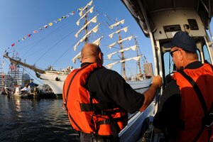 (From left) Lt. Dave Wilder and Mel Vermillion, Ft. Eustis firefighters, watch crowds touring tall ships from Ft. Eustis Fireboat 30 on the Elizabeth River during Norfolk's Operation Sail 2012 event, June 8, 2012. The team participated in rescue response and fire suppression support as part of the Maritime Incident Response Team, a collective of local law enforcement, fire and rescue, state and federal agencies providing maritime assets to respond to waterfront and waterborne emergencies. (U.S. Air Force photo by Senior Airman Wesley Farnsworth/Released)