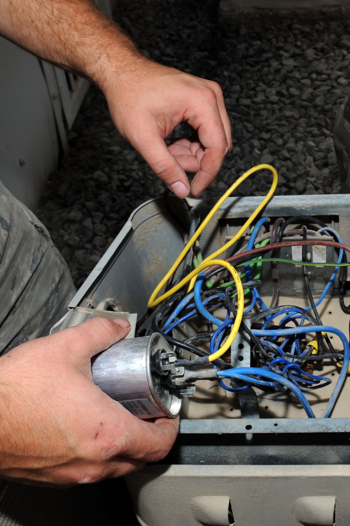 SOUTHWEST ASIA - Senior Airman Erik Nelson, 380th Air Expeditionary Civil Engineer Squadron Heating, Ventilation, Air Conditioning and Refrigeration technician, inspects the wiring of an AC unit outside of the 380th Air Expeditionary Wing headquarters building June 8, 2012. The HVAC/R section is open 24 hours a day, seven days a week providing this vital mission support. (U.S. Air Force photo/Master Sgt. Scott MacKay)