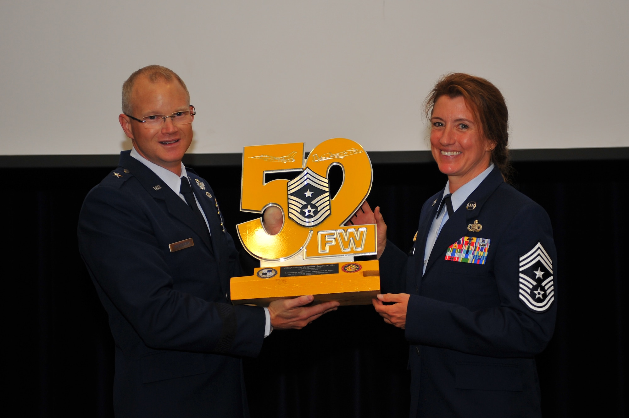 SPANGDAHLEM AIR BASE, Germany -- Brig. Gen. Chris Weggeman, left, 52nd Fighter Wing commander, presents a token of appreciation to Chief Master Sgt. Sandra Miller, 52nd FW command chief, during Miller’s retirement ceremony inside the Club Eifel ballroom here June 8. Miller retired after 29 years of service and more than 150 people attended the ceremony to celebrate her transition into civilian life. (U.S. Air Force photo by Airman 1st Class Dillon Davis/Released)