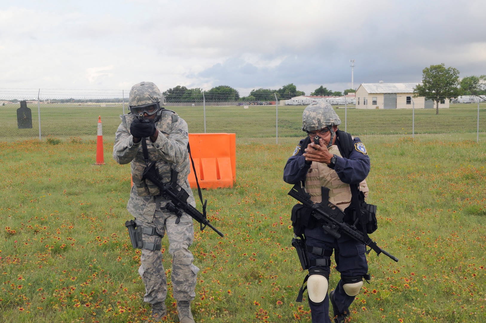 Airman 1st Class Martin and Officer Agapito Delarosa, 902nd Security Forces Squadron installation police officers, move toward their target during Shoot, Move and Communicate training at Camp Talon on Joint Base San Antonio- Randolph, June 7.  (U.S. Air Force Photo by Don Lindsey)