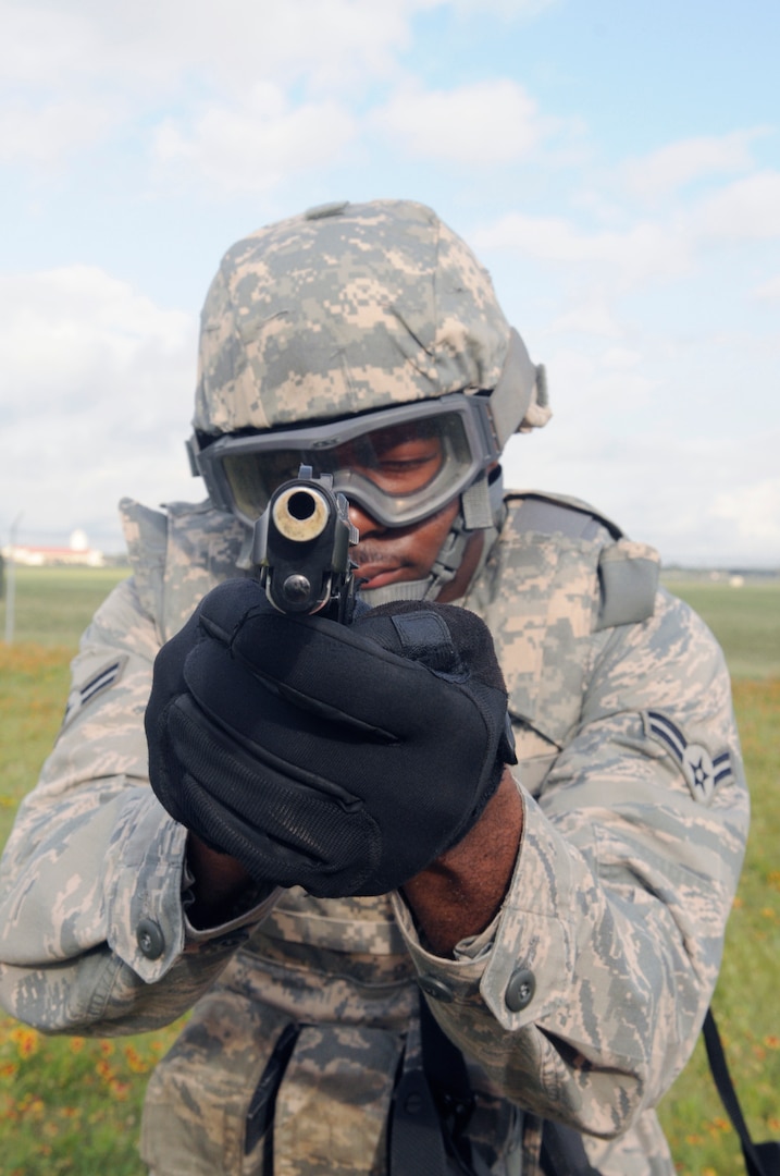 Airman 1st Class Carl Martin, 902nd Security Forces Squadron installation police officer, points his pistol at a perpetrator during Shoot, Move and Communicate training at Camp Talon on Joint Base San Antonio- Randolph, June 7.  (U.S. Air Force Photo by Don Lindsey)