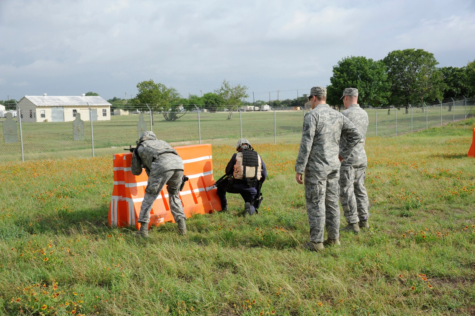 Instructors from the 902nd Security Forces Squadron provide guidance to trainees as they prepare to shoot at their targets during Shoot, Move and Communicate training at Camp Talon on Joint Base San Antonio- Randolph, June 7.  (U.S. Air Force Photo by Don Lindsey)