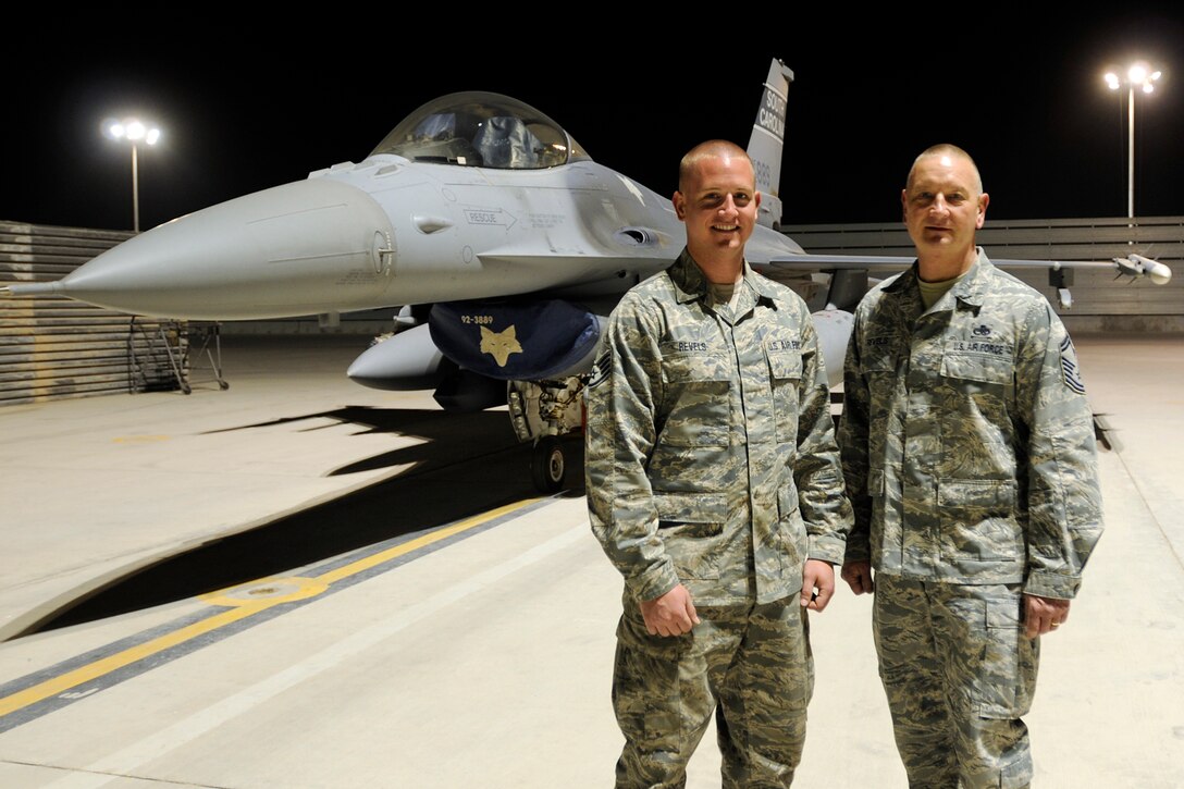 Staff Sgt. Corey Revels, an avionics technician assigned to the 451st Expeditionary Aircraft Maintenance Squadron and his father, Senior Master Sgt. James Revels, Jr., superintendent for the 451st Expeditionary Maintenance squadron, pose for a photo in front of an F-16 Fighting Falcon May 31, 2012. Personnel are deployed from McEntire Joint National Guard Base, S.C., in support of Operation Enduring Freedom. Swamp Fox F-16?s, pilots, and support personnel began their Air Expeditionary Force deployment early April to take over flying missions for the air tasking order and provide close air support for troops on the ground in Afghanistan.
(U.S. Air Force photo/TSgt. Caycee Cook)
