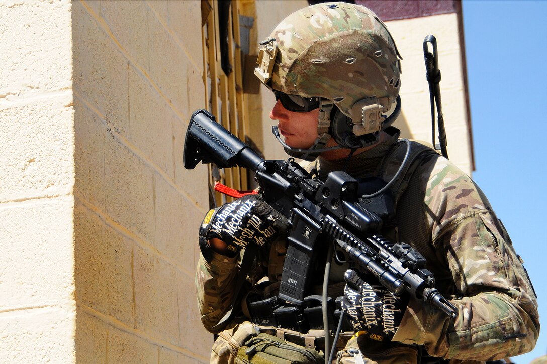 U.S. Army Sgt. 1st Class Michael Nelson looks around the corner of a building while 
providing security during a key leader engagement in Cin Farsi Village in Afghanistan's Farah province, June 9, 2012. Nelson is assigned to Provincial Reconstruction Team.