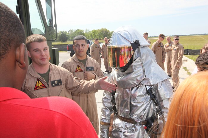 Marine Corps Air Station New River Aircraft Rescue and Firefighting Marines give a tour of their vehicles, gear and firehouse to Junior Reserve Officer Training Corps cadets, April 13. Sgt. Michael Utz, ARFF Marine, shows the Pender High School cadets a bunker suit the Marines use while extinguishing flames.