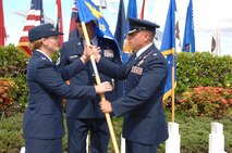 Col. Robie Hughes, 15th Medical Group commander, takes the 15th Medical Support Squadron guidon from Lt. Col. Christopher Dun, outgoing 15th Medical Support Squadron commander, during the 15th MDSS Change of Command ceremony June 12 at Joint Base Pearl Harbor-Hickam, Hawaii. The 15th MDSS was constituted on August 25, 1994 and activated on September 15, 1994. (U.S. Air Force photo by Ed Foster)