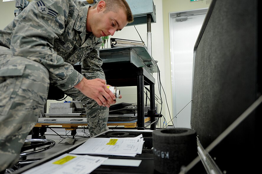 U.S. Senior Airman Dylan White, 18th Component Maintenance Squadron technician, puts away an aircraft weighing system after calibrating it on Kadena Air Base, Japan, June 12, 2012. The Precision Measurement Equipment Laboratory is responsible for a 10,000 machine inventory. (U.S. Air Force photo/ Airman 1st Class Brooke P. Beers)